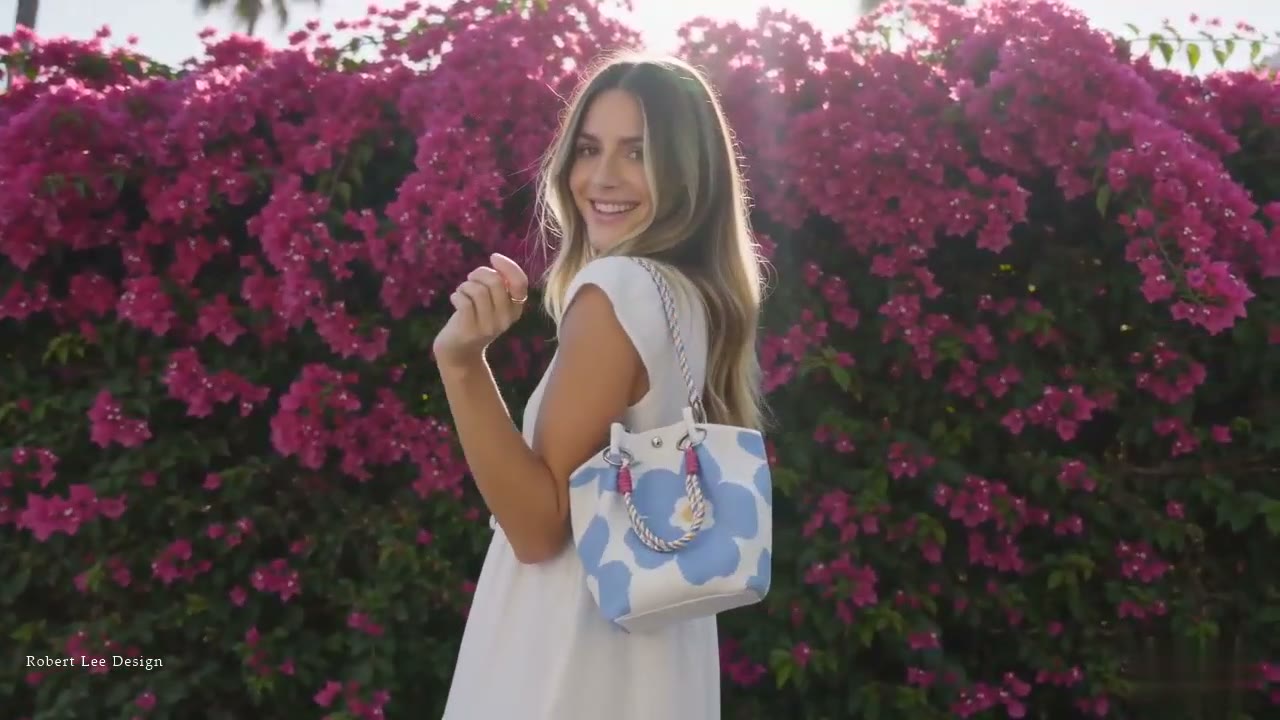 GLAMOR floral bucket bag with a multicolour woven rope handle, carried before a wall of bougainvillea in Los Angeles